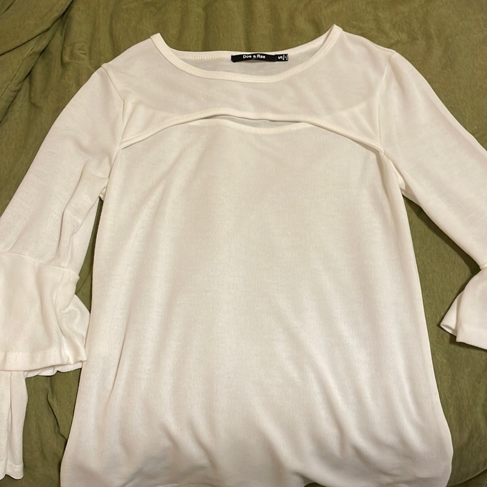 White blouse. Ruffled sleeves. Cut out at the top.